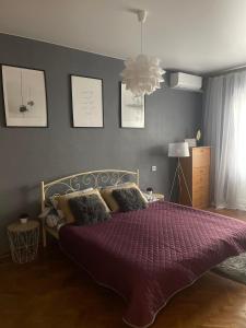 a bedroom with a large bed with a purple comforter at Apartment for a pleasant stay in Odesa