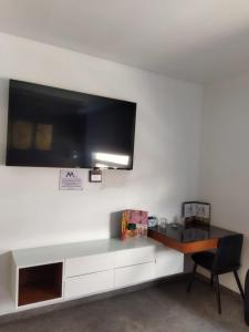 TV en la pared con escritorio y silla en HOTEL M ELITE BLACK en Ciudad de México