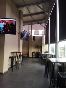 un restaurante con mesas y sillas y TV de pantalla plana en HOTEL M ELITE BLACK en Ciudad de México