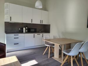 cocina con mesa de madera y armarios blancos en Ferienwohnung Bad Doberan - mit Garten und Terrasse - 2023 neu renoviert, en Bad Doberan