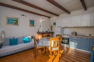 a kitchen with a table and a couch in a room at Holiday house Punta Blue & Orange 5m from the sea, island Cres in Punta Križa