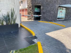 a yellow curb in front of a building at HOTEL M ELITE ROJO in Mexico City +7 photos