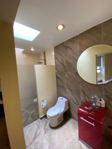 a bathroom with a toilet and a mirror at HOTEL M ELITE ROJO in Mexico City