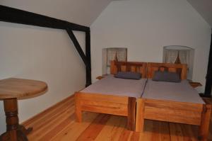 Schlafzimmer mit einem Holzbett und einem Holztisch in der Unterkunft Apartments Koptur in Škocjan