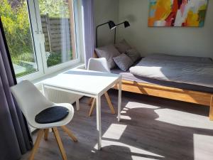 Habitación con cama, escritorio y mesa. en Ferienwohnung Bad Doberan - mit Garten und Terrasse - 2023 neu renoviert, en Bad Doberan