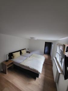 a bedroom with a large bed with white sheets at Hotel CASA ITALIA in Bamberg