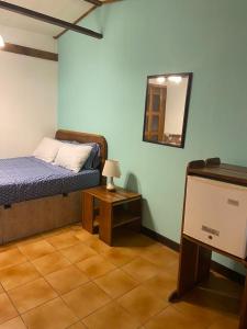 een slaapkamer met een bed, een spiegel en een tafel bij Posada Nena Caribe in Puerto Viejo