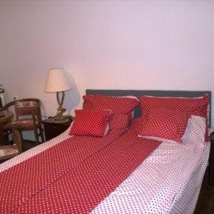 a red and white bed with red pillows on it at Villa Délibáb in Badacsonytomaj