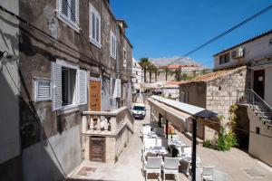 une allée avec des tables et des chaises dans un bâtiment dans l'établissement Korkyra Central Rooms, à Korčula