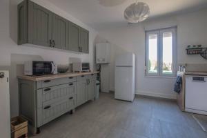 uma cozinha com um frigorífico branco e uma janela em GITE DE MIRAUVILLE em Apremont-la-Forêt