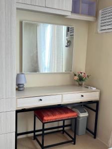 a dressing table with a mirror and a stool at AVIDA ATRIA Tower 3 in Iloilo City