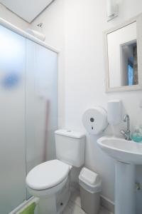 a white bathroom with a toilet and a sink at Aconchego Azul Suítes Vila Mariana in Sao Paulo +47 photos