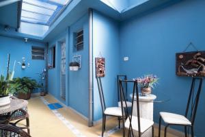 um quarto azul com cadeiras e uma parede azul em Aconchego Azul Suítes Vila Mariana em São Paulo