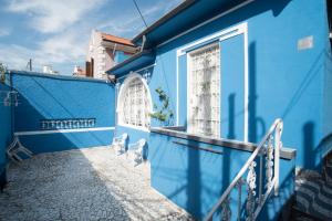 una casa azul con una escalera que conduce a una ventana en Aconchego Azul Suítes Vila Mariana, en São Paulo
