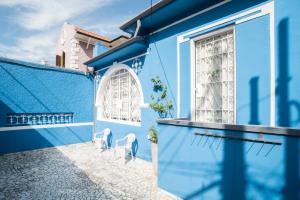 a blue house with two chairs in front of it at Aconchego Azul Suítes Vila Mariana in Sao Paulo