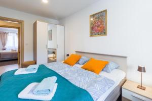 1 dormitorio con 1 cama grande con almohadas de color naranja y azul en NEW!!! Apartment Alex on Perfect Location, en Poreč
