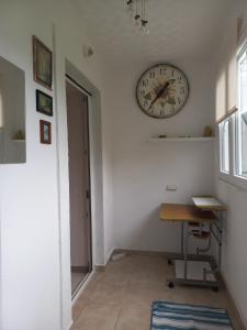 Habitación con reloj en la pared y escritorio. en Your Space, en Donji Stoliv