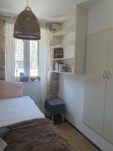 een slaapkamer met een bed, een stoel en een raam bij Our Best Chapter in Split