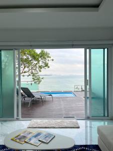 una sala de estar de planta abierta con vistas al océano en Family Cliff House - private jacuzzi with beach views en Pathiu