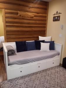 een wit bed met blauwe kussens in een kamer bij Forest Sweet Retreat Hot Tub & Wood Fired Sauna in Ucluelet