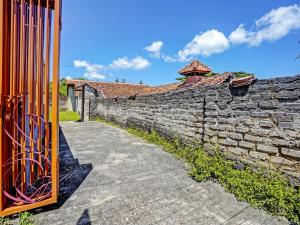 pared de piedra con puerta y pasarela en SPOT ON 92527 Penginapan Kangean Syariah, en Sumenep