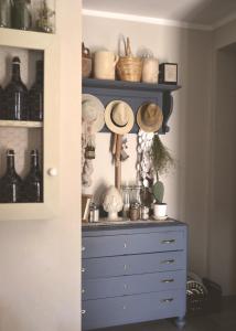 a room with a blue dresser with hats and glasses at B&B La Casa Pugliese in Foggia