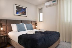 sypialnia z dużym łóżkiem z niebieskimi poduszkami w obiekcie Invicta Premium - Downtown apartment w Porto