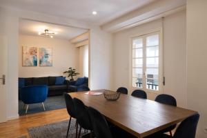 uma sala de estar com uma mesa de madeira e cadeiras em Invicta Premium - Downtown apartment no Porto
