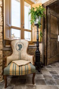 a chair sitting in a room with a window at Via Roma Charming Rooms in Baunei