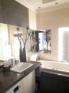 a bathroom with a white sink and a bath tub at Apartament nad jeziorem w Brodnicy in Brodnica