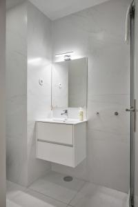 biała łazienka z umywalką i prysznicem w obiekcie Invicta Premium - Downtown apartment w Porto