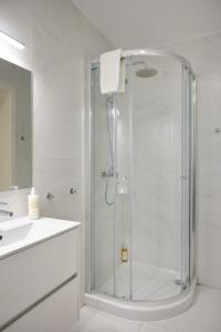 uma casa de banho com um chuveiro e uma cabina de duche em vidro. em Invicta Premium - Downtown apartment em Porto