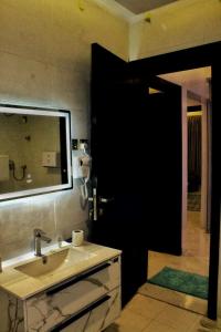 La salle de bains est pourvue d'un lavabo et d'une porte noire. dans l'établissement شاليهات ميلانا, à Khamis Mushait