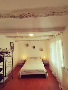 ein Schlafzimmer mit einem Bett und einem großen Fenster in der Unterkunft Maison Ellie, Pézenas centre in Pézenas