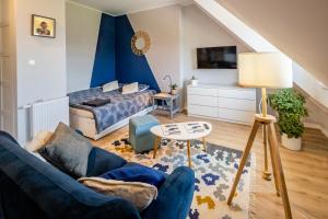 a living room with a blue couch and a bed at Apartament Zakatek z miejscem parkingowym in Bielsko-Biala