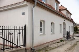 una casa blanca con una valla negra en Apartament Zakatek z miejscem parkingowym, en Bielsko-Biala