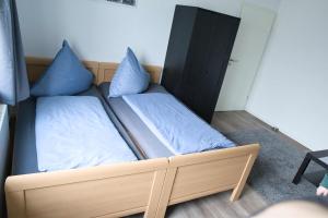 Bett mit blauen Kissen auf einem Zimmer in der Unterkunft Heide Ferienwohnung in Schneverdingen