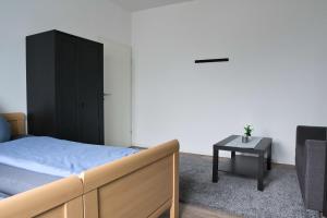 ein Schlafzimmer mit einem Bett, einem schwarzen Schrank und einem Tisch in der Unterkunft Heide Ferienwohnung in Schneverdingen