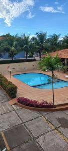 a swimming pool in a resort with a palm tree at Solar das Ostras Salinopólis in Salinópolis