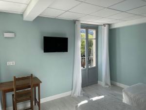 a room with a bed and a television on a wall at Hôtel La Vigneraie in Levens