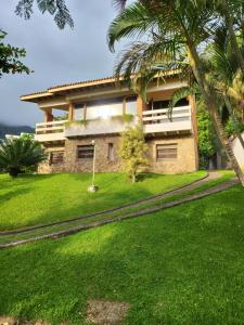 une maison sur une colline avec une cour verdoyante dans l'établissement Green Toque-Toque, à São Sebastião