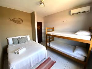 a bedroom with two beds and a bunk bed at Parnaíba Hostel in Parnaíba