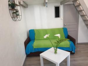 salon z zieloną kanapą i stołem w obiekcie Au pied du Baou w mieście Saint-Chamas