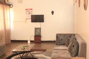 a living room with a couch and a table at Maison de 3 chambres dans un lieu apaisé au centre de Kigali in Kigali