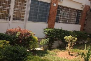a house with a bunch of bushes in front of it at Maison de 3 chambres dans un lieu apaisé au centre de Kigali in Kigali