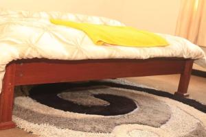 a rug under a bed with a blanket on top at Maison de 3 chambres dans un lieu apaisé au centre de Kigali in Kigali