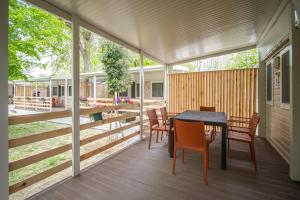 a screened porch with a table and chairs at Mobile Home in Duna Verde