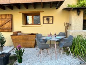 a patio with a table and chairs in front of a house at Gite Au Grenier Cosy in Lor
