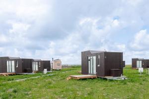 a row of tiny houses sitting in a field at Tiny House Nature 11 Innenlage - Green Tiny Village Harlesiel in Carolinensiel