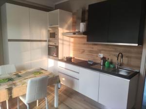 a kitchen with white cabinets and a table and a sink at stanzadadanilo in Monza